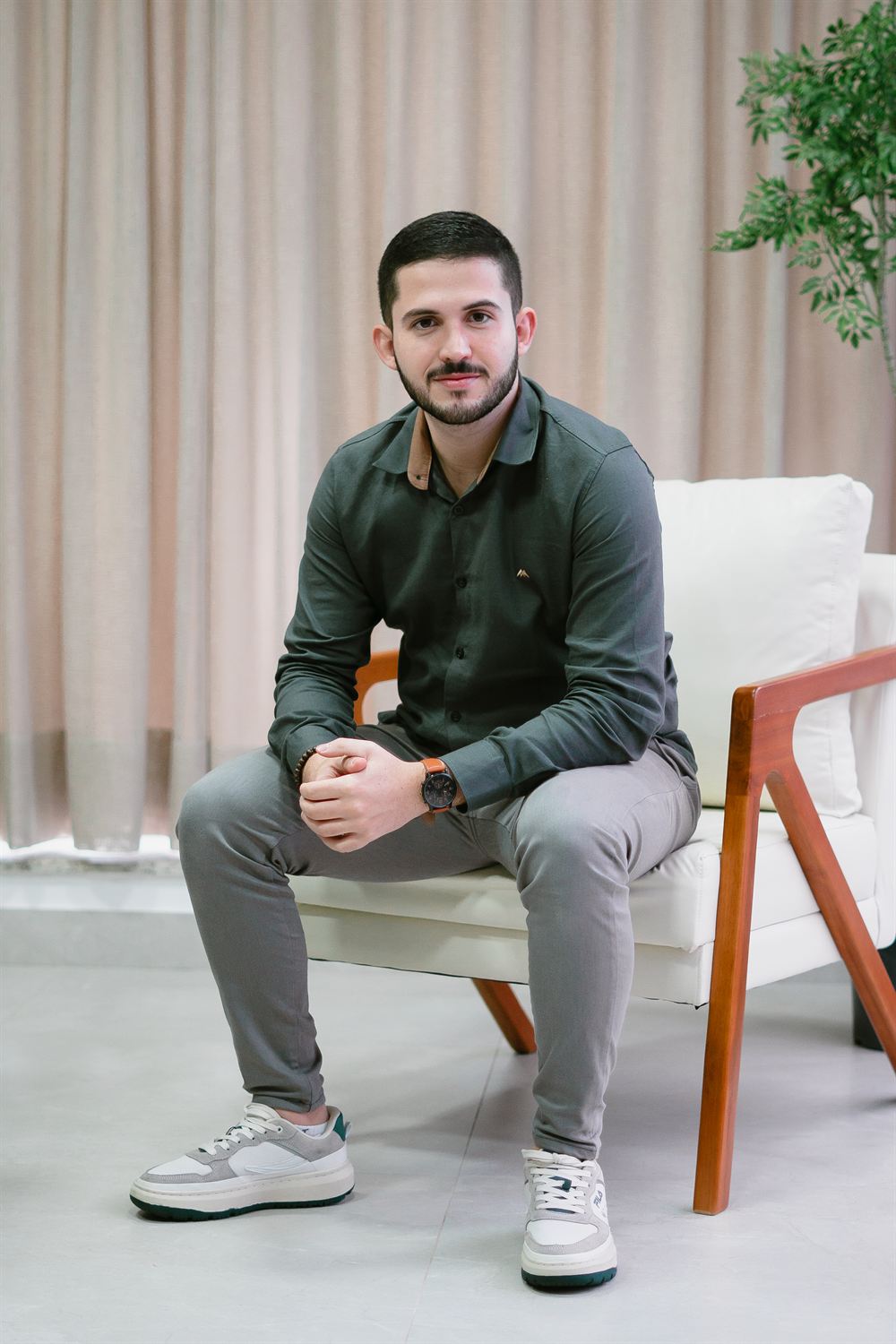 Nutricionista Matheus Henrique sentado na poltrona do consultório